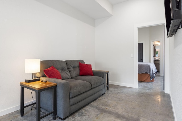 living room featuring finished concrete floors and baseboards