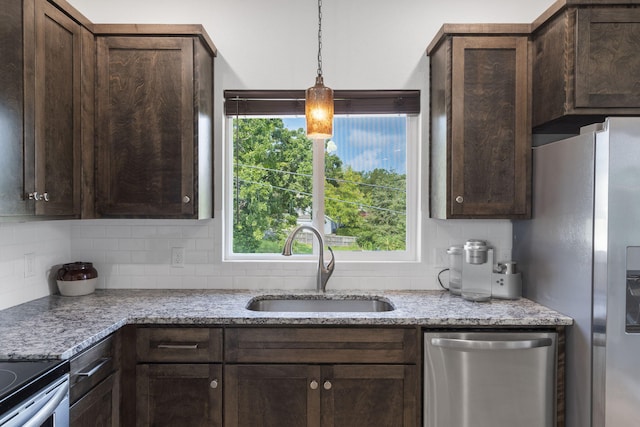 kitchen featuring dark brown cabinetry, decorative backsplash, stainless steel appliances, and a sink