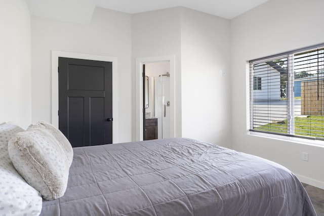 bedroom with ensuite bath and baseboards