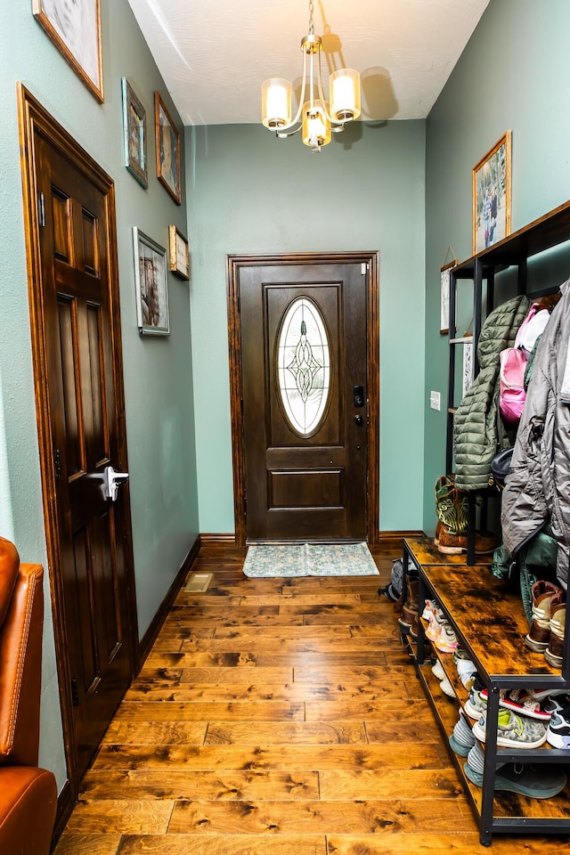 entrance foyer with hardwood / wood-style floors and a chandelier