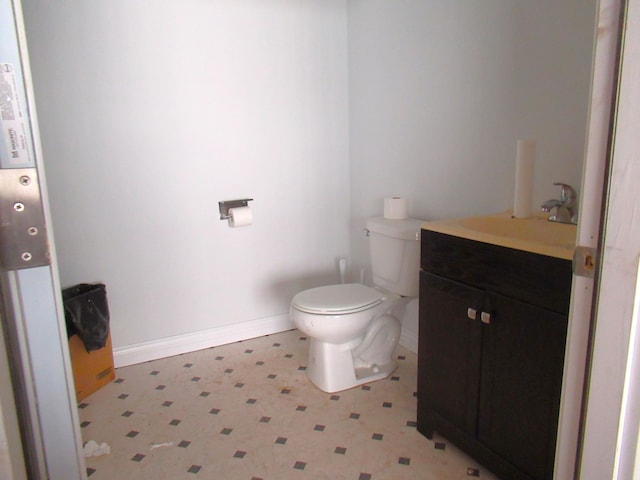 bathroom featuring tile patterned floors, baseboards, vanity, and toilet