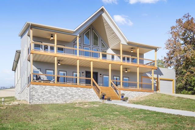 view of front of home featuring a front yard, a balcony, ceiling fan, and covered porch