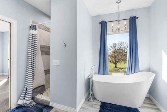 bathroom with wood-type flooring, plus walk in shower, and an inviting chandelier