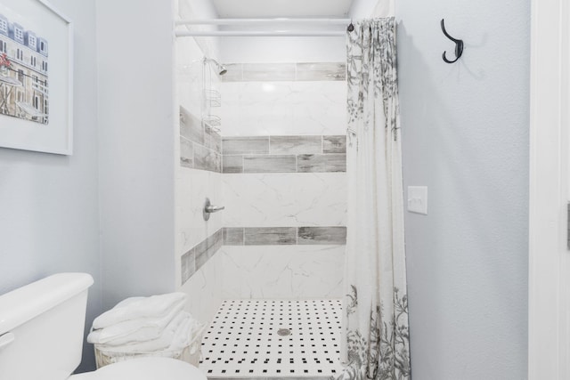 bathroom featuring a shower with shower curtain and toilet