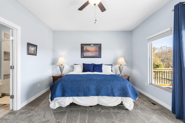 carpeted bedroom featuring multiple windows, ensuite bathroom, and ceiling fan