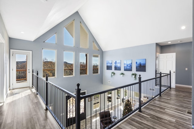 corridor featuring hardwood / wood-style floors and high vaulted ceiling