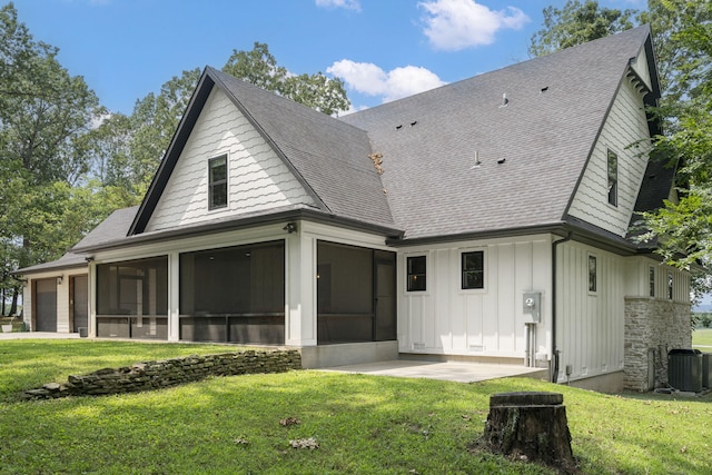 rear view of house with a sunroom, a lawn, and central air condition unit