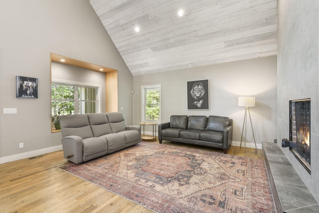 living room with a fireplace, wooden ceiling, high vaulted ceiling, and light hardwood / wood-style flooring