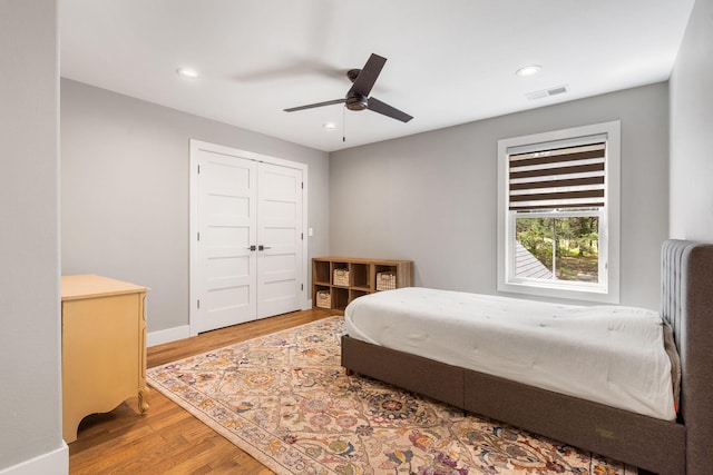 bedroom with ceiling fan, a closet, and hardwood / wood-style floors