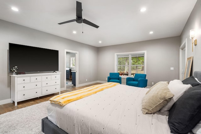 bedroom with hardwood / wood-style floors, ensuite bathroom, and ceiling fan