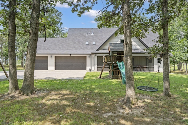 view of front of house featuring a front lawn, a playground, and a garage