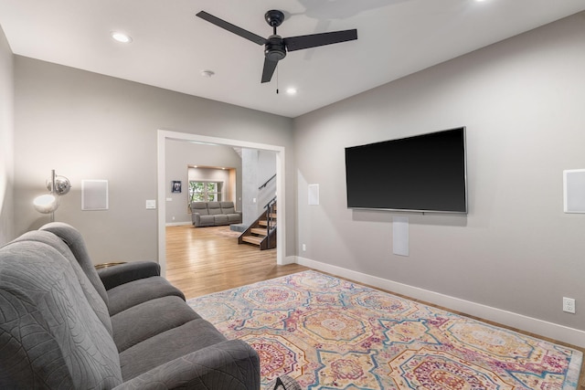 living room featuring ceiling fan and light hardwood / wood-style floors