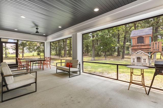 sunroom / solarium featuring ceiling fan and wooden ceiling