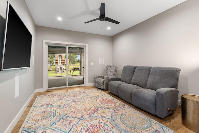 living room with ceiling fan and light hardwood / wood-style flooring