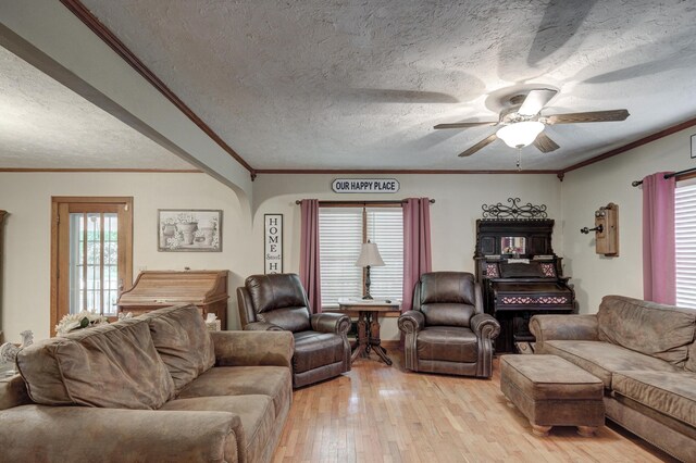 living room with ceiling fan, a textured ceiling, light hardwood / wood-style flooring, and crown molding