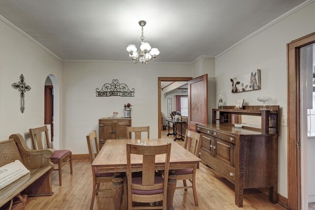 dining room featuring an inviting chandelier, light wood-type flooring, and crown molding