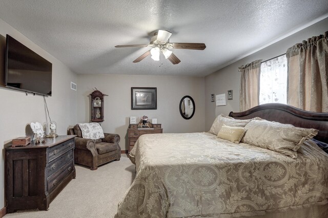 carpeted bedroom with ceiling fan and a textured ceiling