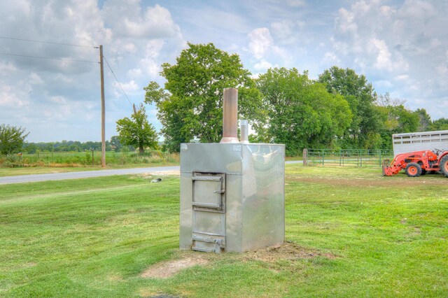 view of storm shelter with a rural view and a lawn