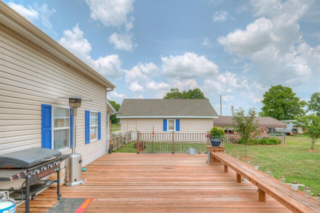 wooden terrace featuring area for grilling and a lawn