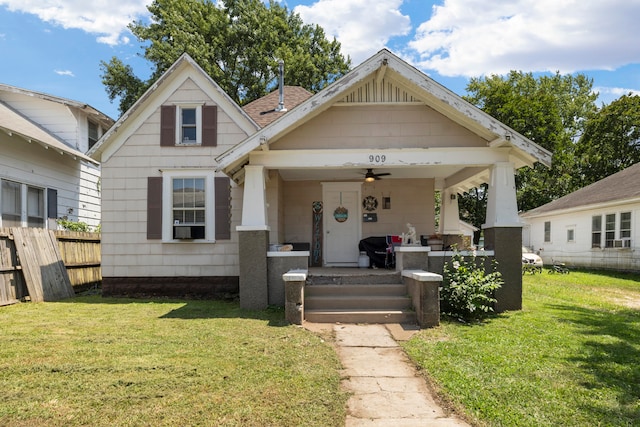 view of front of property featuring cooling unit, a front lawn, and covered porch