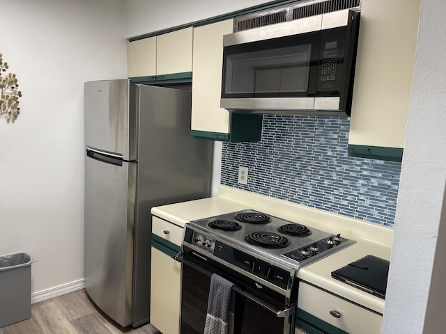 kitchen featuring light hardwood / wood-style floors, appliances with stainless steel finishes, and backsplash