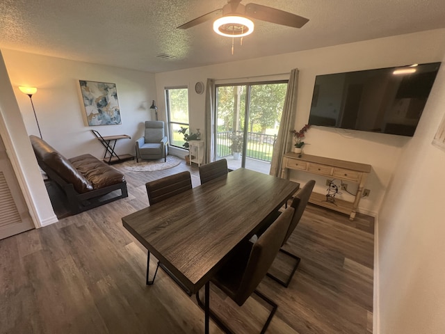 dining room with ceiling fan, dark hardwood / wood-style floors, and a textured ceiling