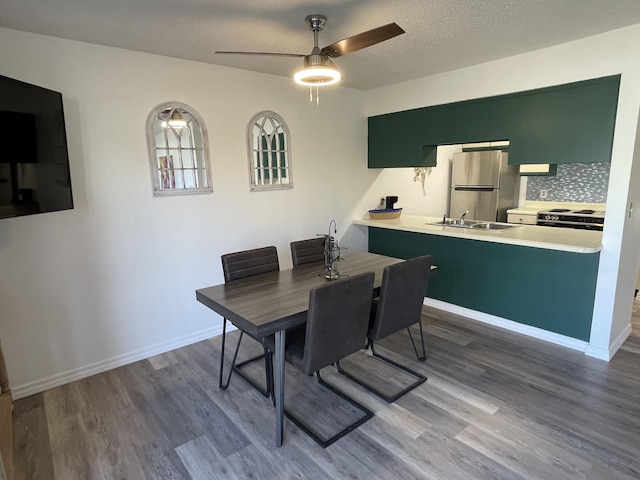 dining space featuring ceiling fan, sink, dark hardwood / wood-style floors, and a textured ceiling