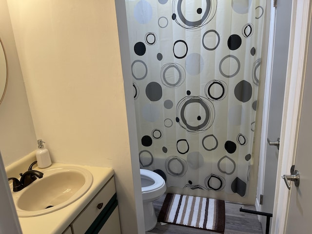 full bathroom with wood-type flooring, vanity, shower / tub combo, and toilet