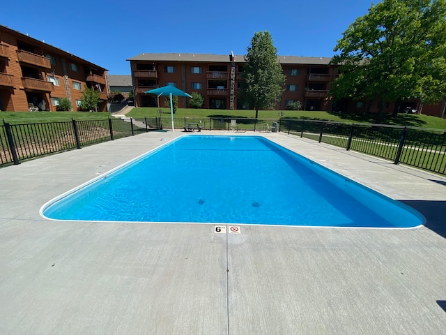 view of pool featuring a lawn