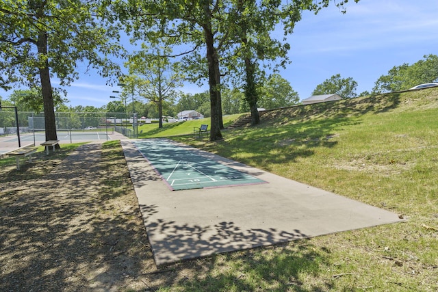 view of community with tennis court and a lawn