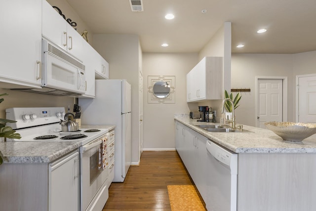 kitchen with white cabinets, hardwood / wood-style flooring, white appliances, sink, and kitchen peninsula