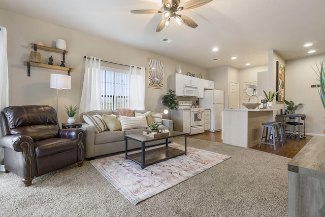 living room with ceiling fan and dark wood-type flooring