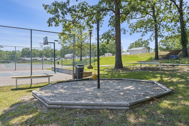 surrounding community featuring basketball hoop and a yard