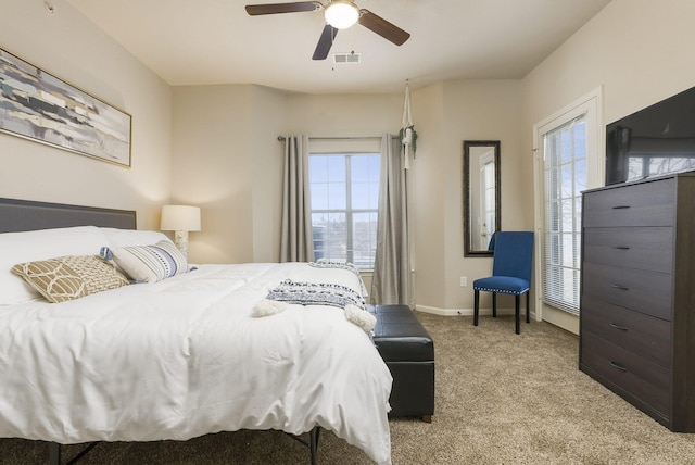 bedroom featuring multiple windows, ceiling fan, and light colored carpet