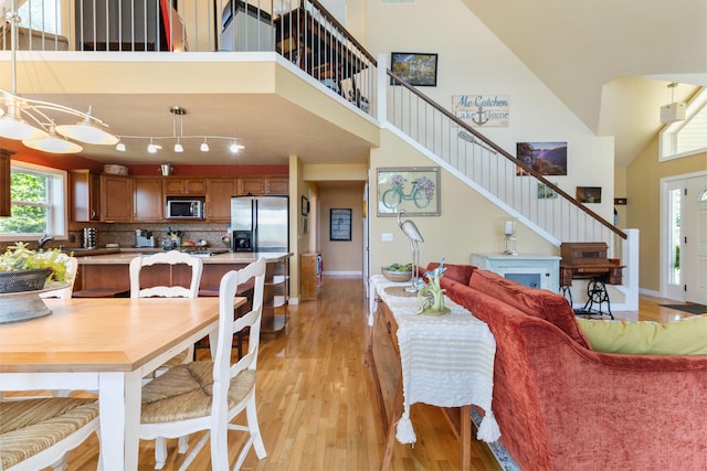 dining space featuring a chandelier, a high ceiling, light hardwood / wood-style flooring, and sink