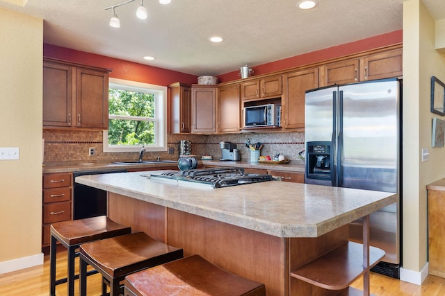 89 Turkey Trl, Blue Eye, MO 65611 - kitchen featuring light wood finished floors, tasteful backsplash, open shelves, a kitchen island, and appliances with stainless steel finishes