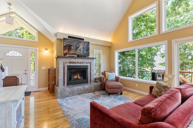 89 Turkey Trl, Blue Eye, MO 65611 - living area featuring light wood-style floors, a tiled fireplace, and high vaulted ceiling