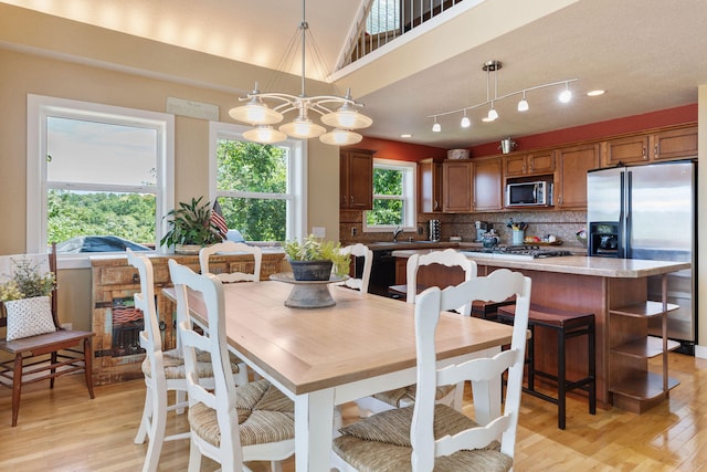 dining area with a chandelier, sink, and light hardwood / wood-style floors