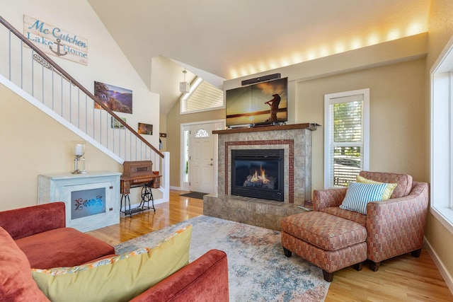 89 Turkey Trl, Blue Eye, MO 65611 - living area with a tile fireplace, stairway, wood finished floors, baseboards, and high vaulted ceiling