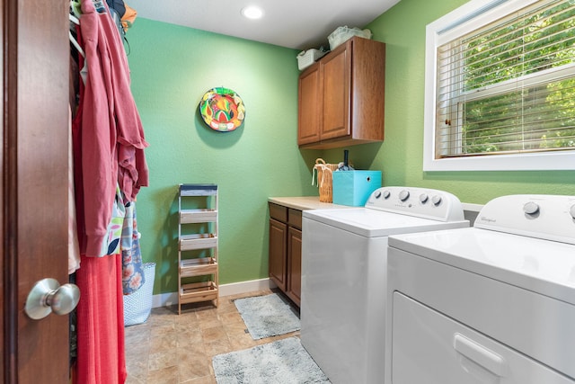 laundry area with washer and dryer and cabinets