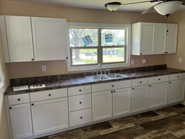 106 Martin St, Licking, MO 65542 - kitchen featuring dark wood finished floors, dark countertops, white cabinetry, and a sink
