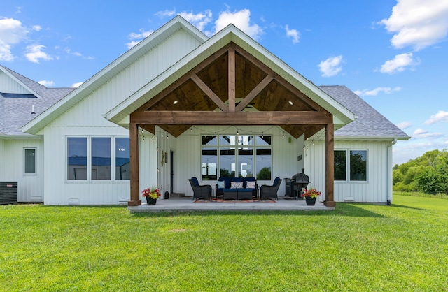 back of property with outdoor lounge area, a lawn, and a patio area