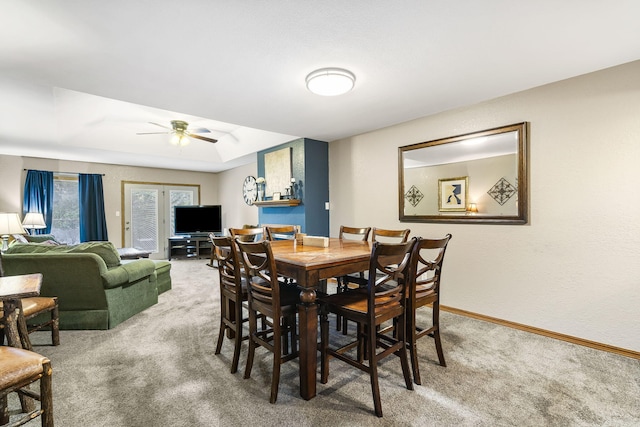 carpeted dining space with ceiling fan