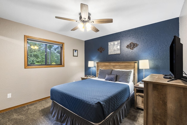 carpeted bedroom with ceiling fan, baseboards, and a textured wall
