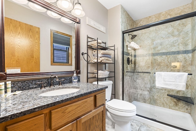 bathroom with vanity, tile patterned flooring, toilet, and an enclosed shower