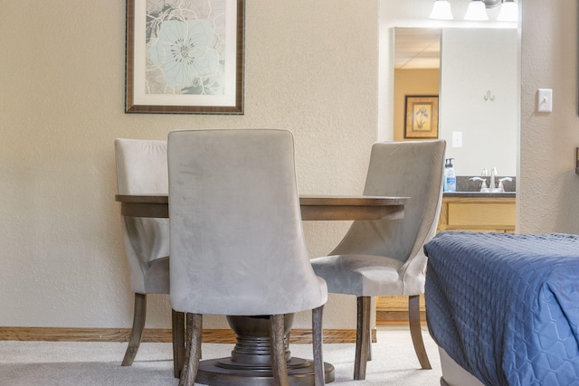 carpeted dining room featuring a textured wall
