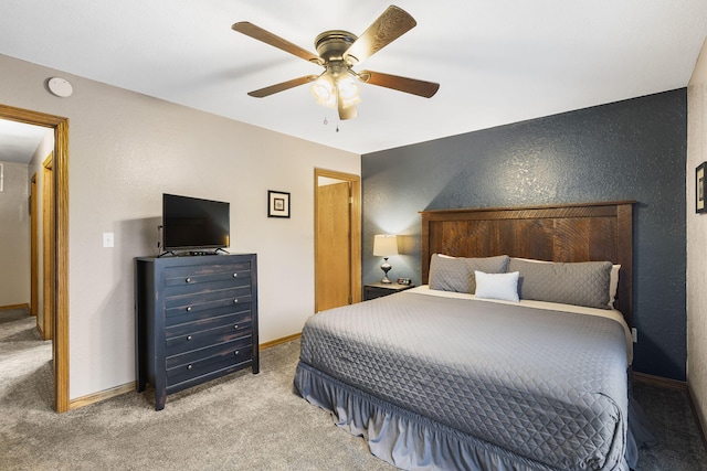 bedroom featuring ceiling fan, baseboards, a textured wall, and carpet