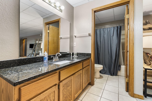 full bathroom featuring shower / tub combo with curtain, vanity, a paneled ceiling, tile patterned flooring, and toilet