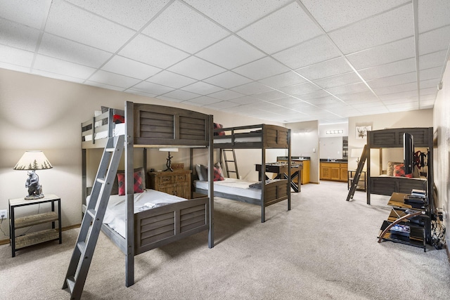 bedroom with carpet floors and a paneled ceiling