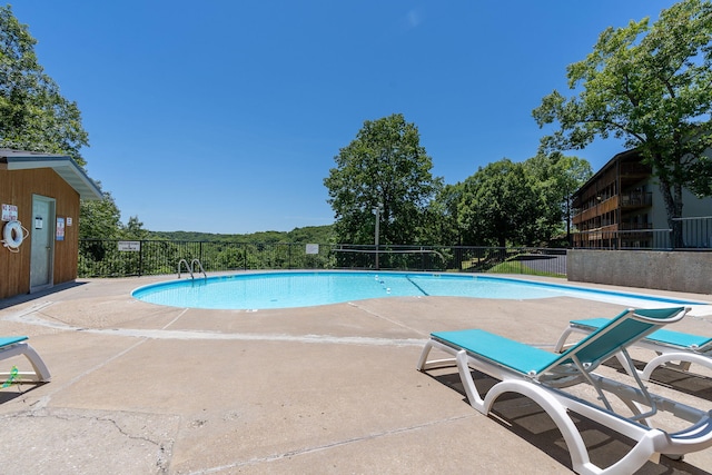 community pool featuring fence and a patio